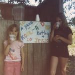 Jessica and Kathleen sell Kool-Aid at a homemade stand in the back yard. (6/1982)