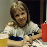 Jessica shrugging at the camera while drawing with markers. (6/1985)