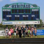 Jessica poses with classmates in front of the Heritage High School scoreboard during a tour for their 20th reunion. (7/25/015)