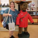 Jessica posing near a stuffed moose, holding her new purchases from the Royal Canadian Mint. (8/24/2016)